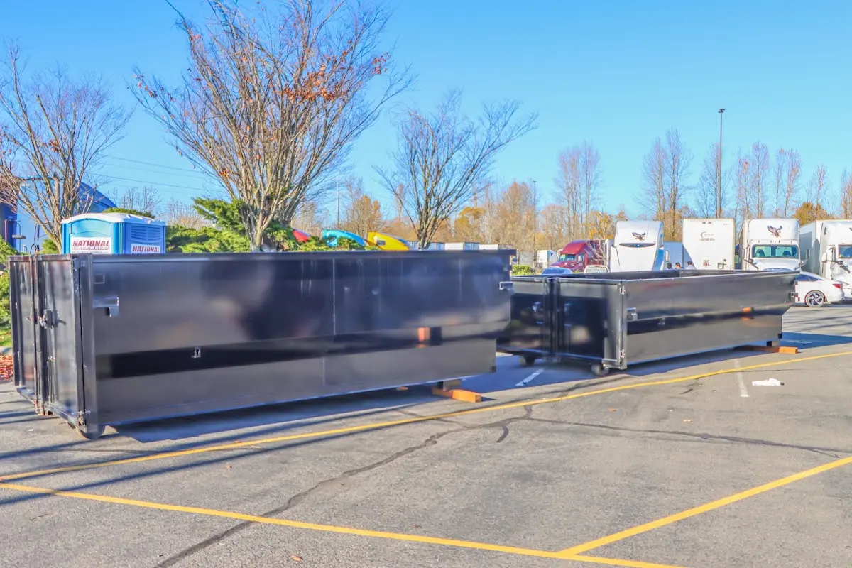 Professional dumpster rental service with roll-off container on residential driveway in East Windsor